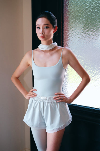 Ballet dancer in Bloom Overlap Dance Shorts showing the front view of the Misted Jade dance shorts with overlapping side panels
