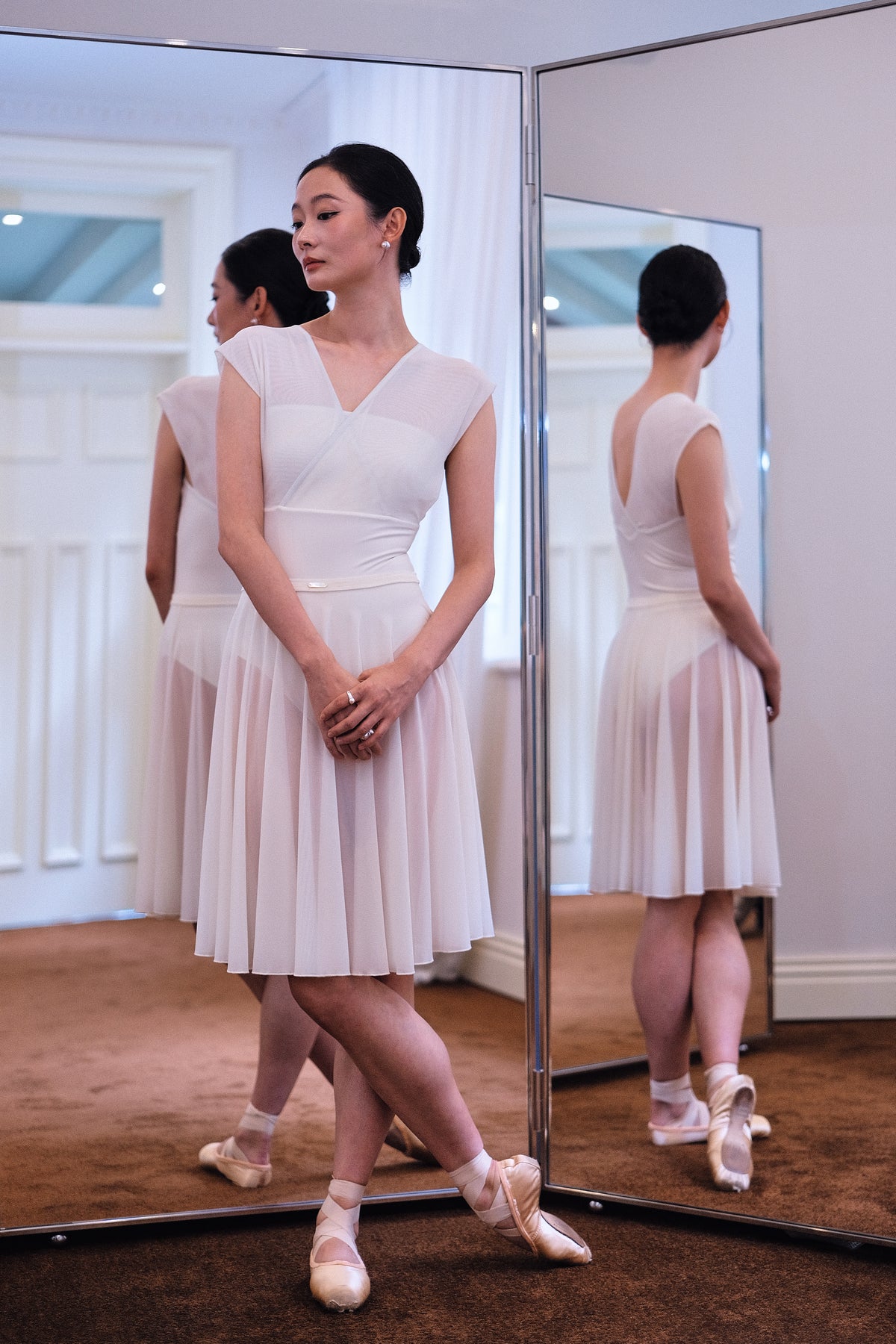 Dancer standing in a Dawn White Pull-On Full-Circle Ballet Rehearsal Skirt and matching leotard, the sheer mesh beautifully drapes to mid-calf 