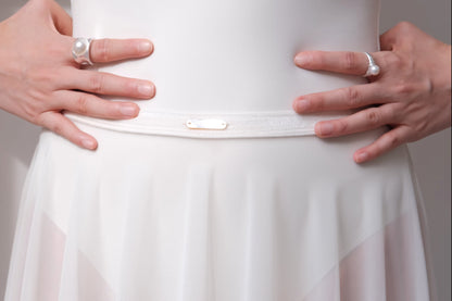 Close-up details of Pull-On Full-Circle Ballet Rehearsal Skirt in dawn white, showing the stretch velvet waistband and the hand-sewn mother-of-pearl tag