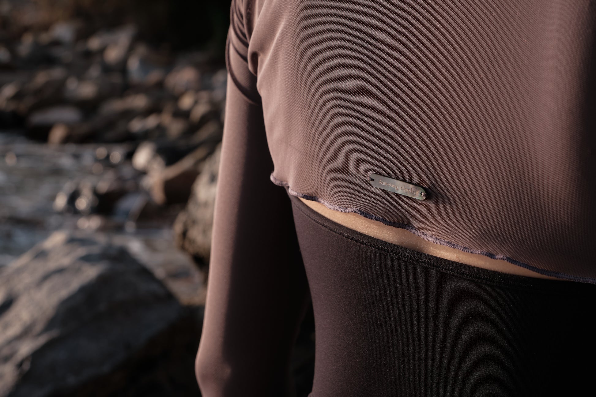 Ultra-Stretch Ballet Mesh Shrug features a hand-sewn logo tag of imported natural Black Mother-of-Pearl in the back for a refined detail